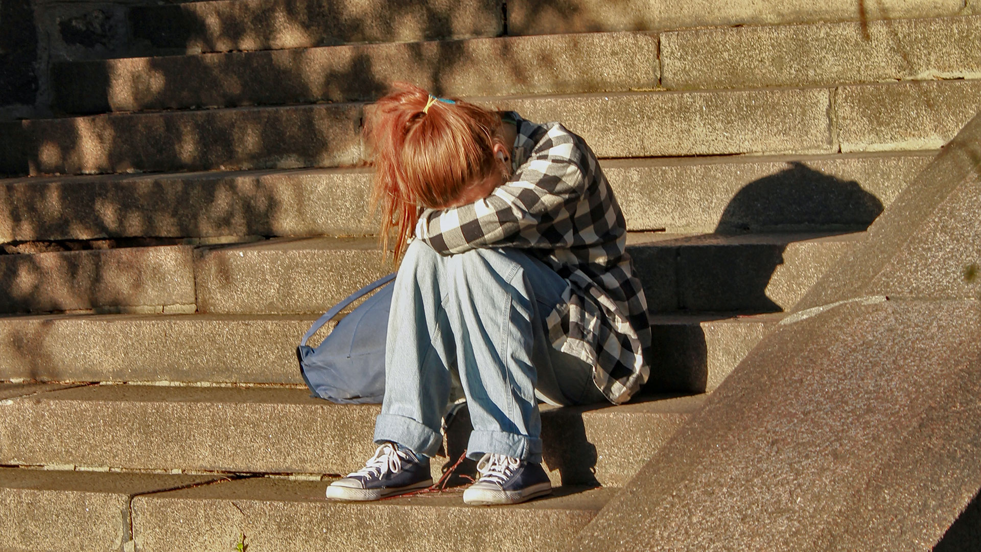 Sad child sits on steps