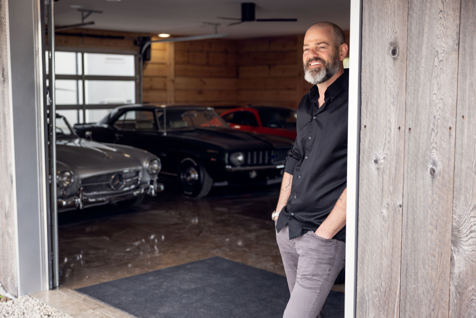 Ryan Finch standing in a garage with vintage cars