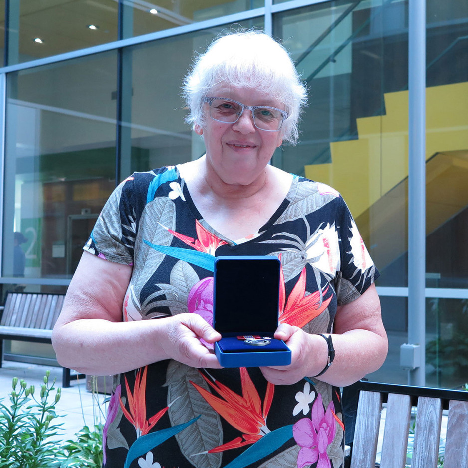 Christine Boyd holds up award