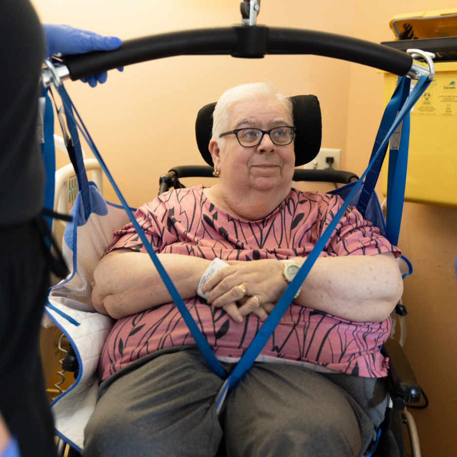 a patient harnessed into a ceiling lift