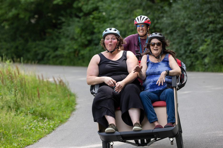 three people riding in a triobike