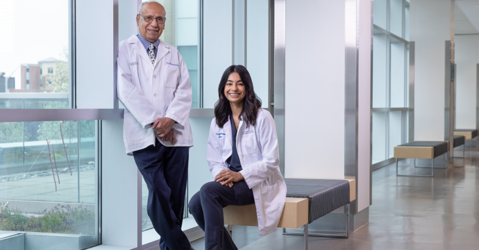 Two doctors in white coats smiling at the camera