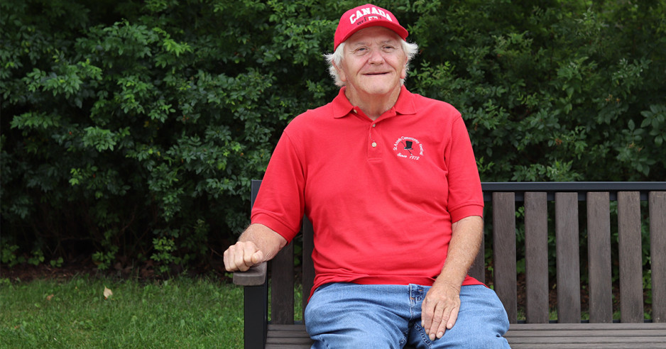 Bill Lee sitting on a bench smiling