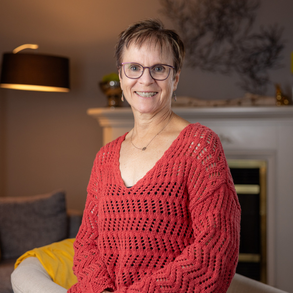 Micheline standing in front of a fireplace