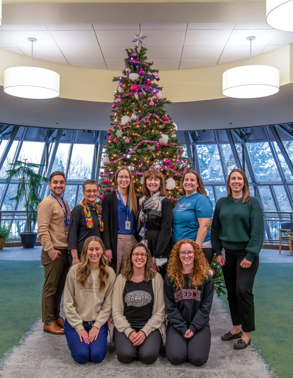 staff in front of Christmas tree