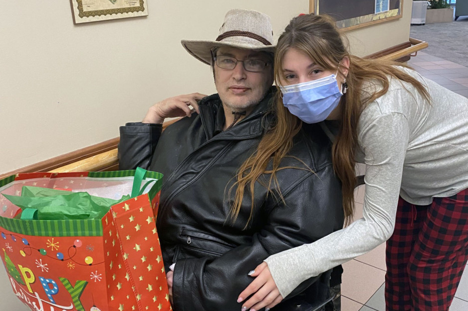 Care provider poses with Mount Hope resident holding gift bag