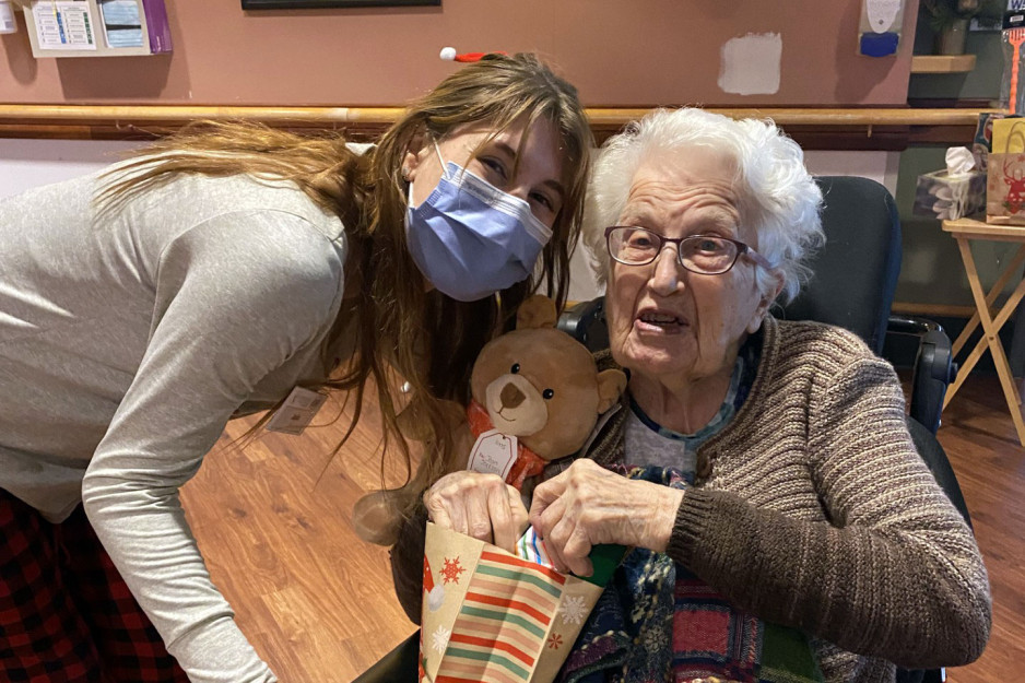 Care provider poses with Mount Hope resident holding gift bag