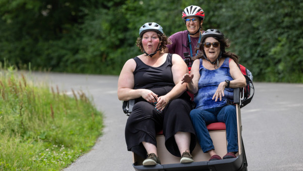 three people riding in a triobike