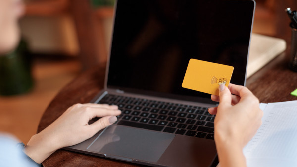 a person using laptop and credit card at home